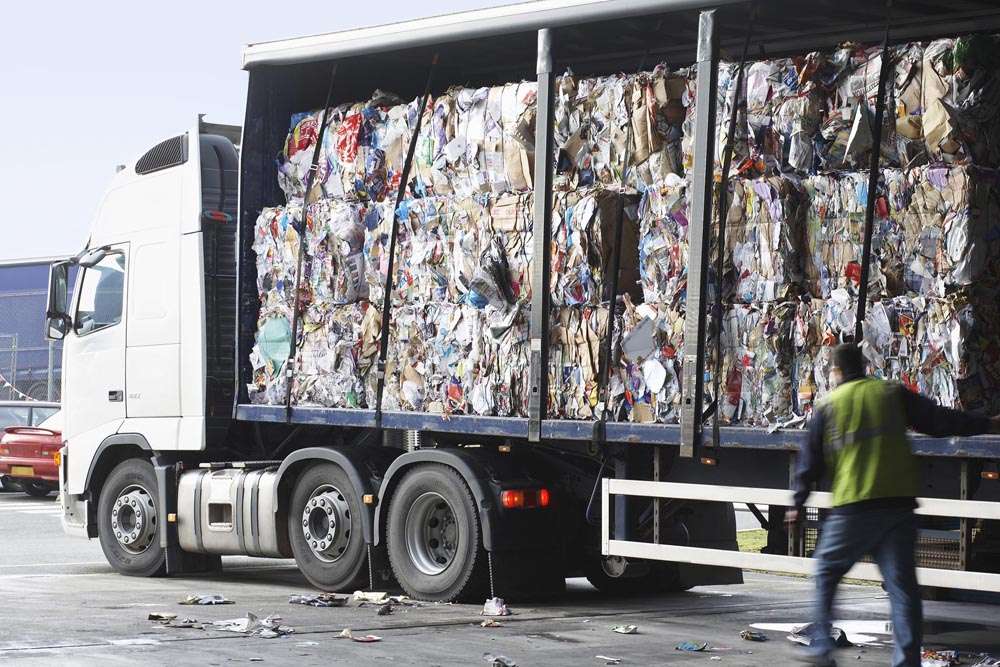 Stacks of recycled paper in lorry at recycling plant